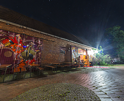 Jugenscheune Ibbebüren Eingang einer Scheune mit einem bunten gemalten Scheuentor